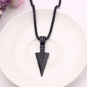 Close-up of a black arrowhead pendant necklace with geometric lines on a bead chain