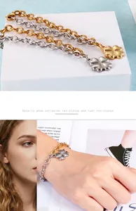 Bracelet trèfle bicolore doré et argenté présenté sur le poignet d'un mannequin