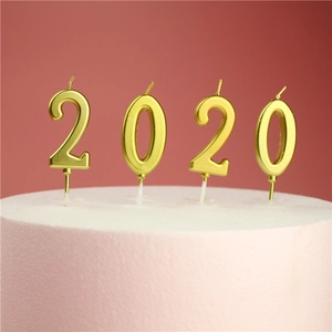 Golden metallic number 2020 candles on cake with pink background for birthday