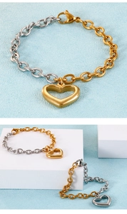 Detailed macro of two-tone chain bracelet with large hollow heart pendant and lobster clasp