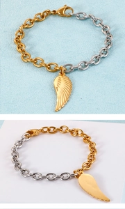 Détail du bracelet chaîne bicolore or et argent avec pendentif en forme d'aile de plume