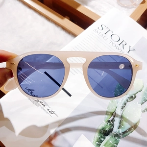 Detail of beige round sunglasses frame with blue lenses and temple size engraving