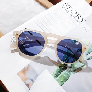 Close-up of beige matte frames and blue lenses sunglasses on a lifestyle magazine