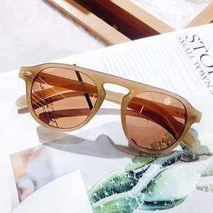Detailed macro view of amber retro round sunglasses with warm orange transparent lenses