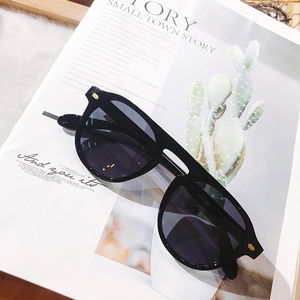 Close-up of black oversized square sunglasses on an editorial lifestyle background