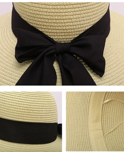 Detail of straw sun hat with black ribbon bow and adjustable interior sweatband