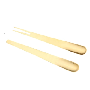 Golden stainless steel fruit fork and dessert spoon set on professional white background