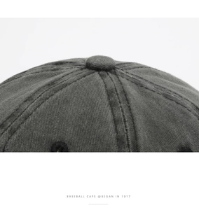 Detail of dark gray washed cotton baseball cap showing top panel seams and stitching