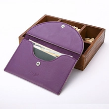 Detailed macro view of purple lychee grain PU leather passport wallet with metal snap button
