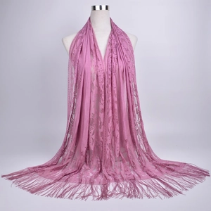 Detail of mauve lace shawl with delicate floral cutouts and long matching tassels