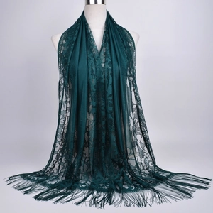 Detailed view of dark green floral lace scarf with long decorative fringe tassels