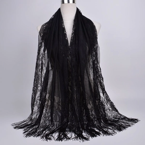 Close-up of black floral lace scarf featuring intricate cutouts and long fringe tassels