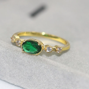 Vintage gold-plated ring with oval emerald gemstone and cubic zirconia accents