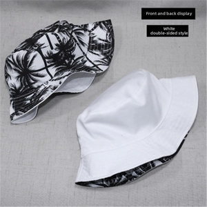 Flat lay of reversible canvas bucket hat showing white side and palm leaf print side