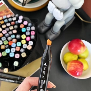 Close-up of an orange broad chisel tip Art Sketch Marker held in hand for precision drawing