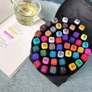 Dual-tip art markers organized in a black fabric case on a cozy desk setup