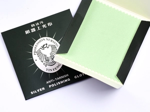 Detail view of mint green silver polishing cloth with its black cardboard packaging sleeve