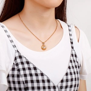 Close-up of a gold titanium steel necklace with a round zircon pendant worn by a model