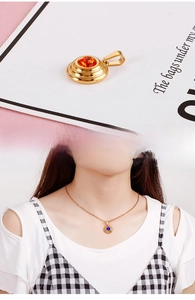 Detail of round gold-plated pendant with sparkling zircon gemstone on fashion necklace