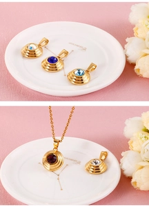Detail view of round gold titanium steel pendants featuring vibrant multi-color zircons