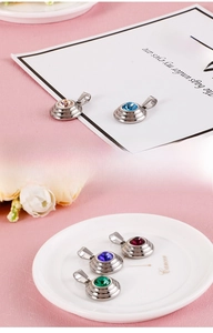 Detail view of round stainless steel pendants featuring vibrant colored zircon stones