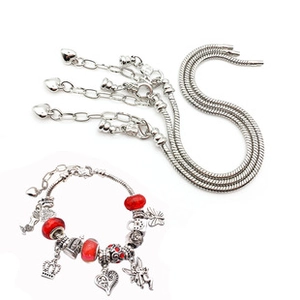 DIY silver charm bracelet with red beads and crown pendants on white background