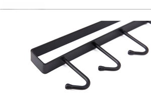 Detail view of black matte metal kitchen hooks with rounded non-slip tips and industrial frame