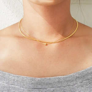 Detailed view of 925 silver double-layered gold necklace with beaded pendant on collarbone