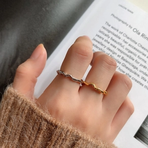Close-up of irregular wavy 925 silver ring worn with a warm knit sweater background