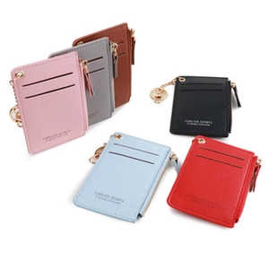 Flat lay of six colorful faux leather coin purses with card slots and golden keyrings