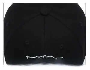 Close-up of black cotton twill baseball cap crown with embroidered eyelets and button