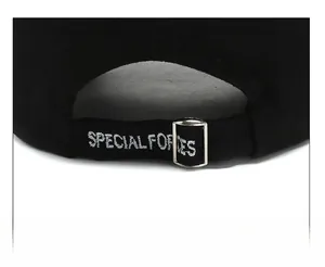 Detail of adjustable strap with silver metal buckle and white embroidery on a black cap