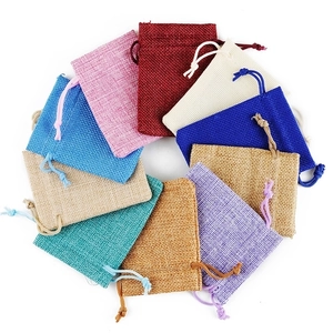 Linen drawstring jewelry pouches in multiple colors arranged in a circle on white background