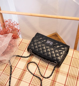 Dettaglio della classica trama trapuntata e chiusura a girello in metallo su borsa nera