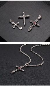 Gothic cross pendants in stainless steel with red gemstone detail on black texture