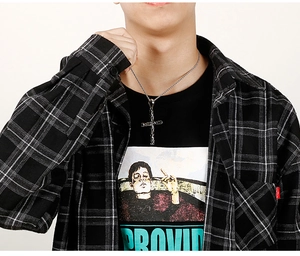 Gros plan du pendentif croix rétro en acier inoxydable pour homme avec chaîne tressée sur modèle