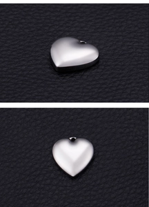 Detailed view of heart-shaped stainless steel charms with polished silver finish on leather