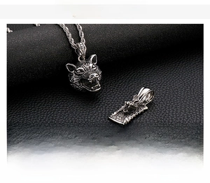 Detail view of retro stainless steel wolf head and dragon relief pendants on black leather