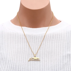 Detail of gold Jamaica map pendant necklace with cursive lettering on a model