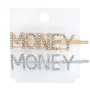 Detail of gold and silver metal hair clips with rhinestone MONEY lettering on card