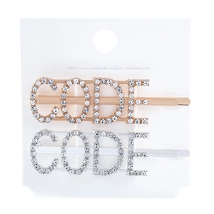Detail of gold and silver rhinestone bobby pins featuring CODE letter design for hair