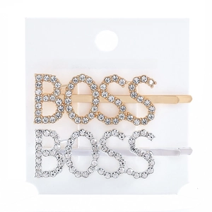 Close-up of gold and silver BOSS metal hair clips with shimmering rhinestone inlay