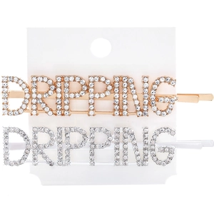 Detail showing gold and silver metal hair clips with Dripping rhinestone lettering
