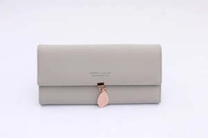 Detail showing high-quality gray leather wallet texture and pink leaf metal charm