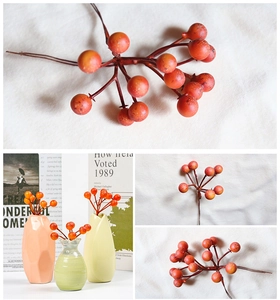 Detail of red and orange artificial berry branches for home floral arrangements