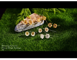 Macro shot of S925 sterling silver anemone flower earrings on natural moss background