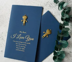 Close-up of luxury navy card with brass metal accent and gold foil sun moon poem