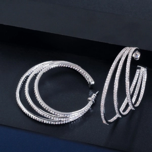 Detailed view of silver triple-layer C-shaped hoop earrings with sparkling zircon inlay