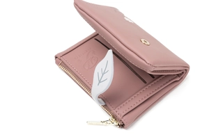 Detailed macro view of pink PU leather wallet interior with card slots and leaf pendant