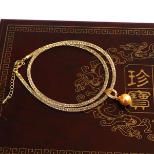 Detail of gold mesh chain necklace with a faux pearl pendant and crystal lobster clasp
